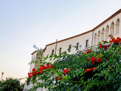 a building with red flowers in front of it at Albergo Palazzo Sant'Anna in Gerace