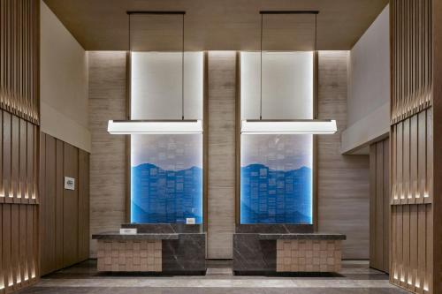 a lobby with two large windows and two lights at Fairfield by Marriott Changchun Chaoyang in Changchun