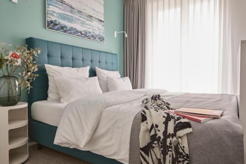 a bedroom with a bed with a blue headboard at Atlantic Dependance Travemünde in Travemünde