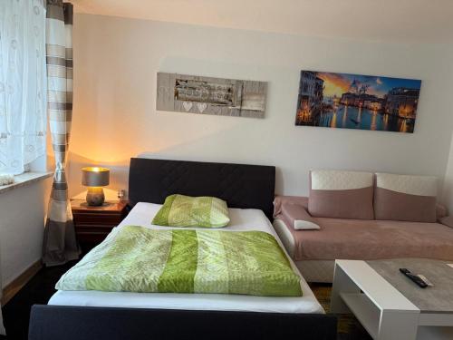 a bedroom with a bed and a couch at City Ferienwohnung Bayreuth in Bayreuth