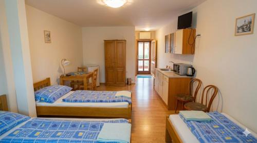 a hotel room with two beds and a kitchen at Alva Pension 2 in Mikulov