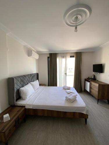a bedroom with a large bed and a large window at Ayvalik Bir Tebessum in Ayvalık