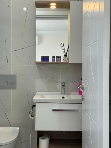 a white bathroom with a sink and a toilet at Ayvalik Bir Tebessum in Ayvalık