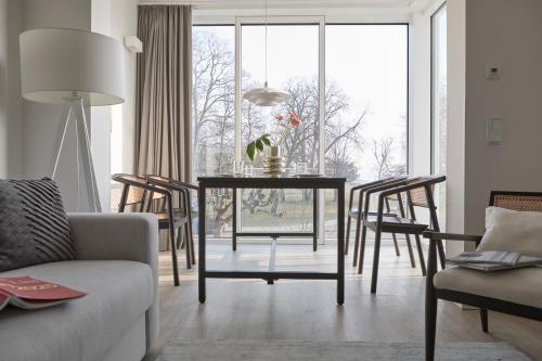a living room with a dining room table with chairs at Atlantic Dependance Travemünde in Travemünde