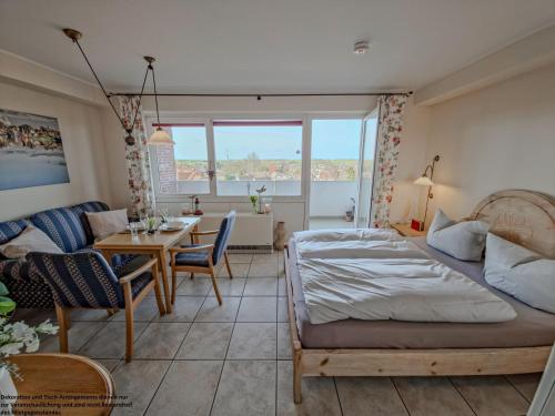 a bedroom with a bed and a living room at FeWo Sonnenschein mit Pool & Balkon in Horumersiel