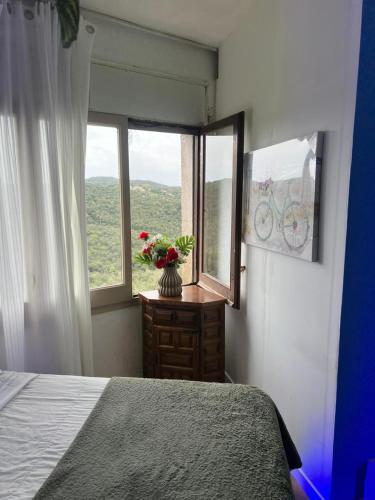 a bedroom with a bed and a window with a vase of flowers at habitacion a 15 min playa d aro in Romanyá de la Selva