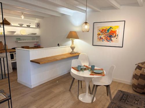 a kitchen with a table and chairs and a counter at Les Suites du Midi in Saint-Paul-dʼEspis
