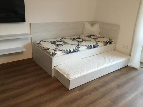 a small bedroom with a bed with a white mattress at Apartmány Zuberec 893 in Zuberec
