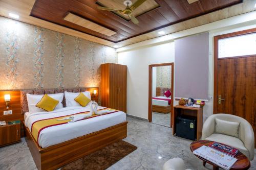 a bedroom with a bed and a chair in it at Aarchh Royale in Noida