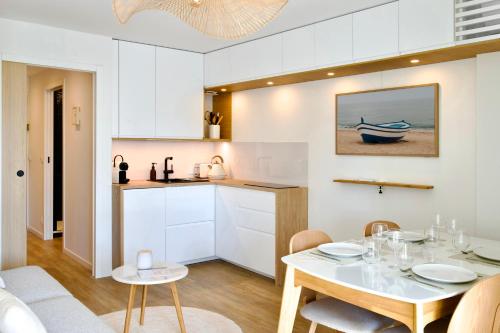 a kitchen and dining room with a white table and chairs at La Loggia du Triton - Superbe T2 avec parking in Le Grau-du-Roi