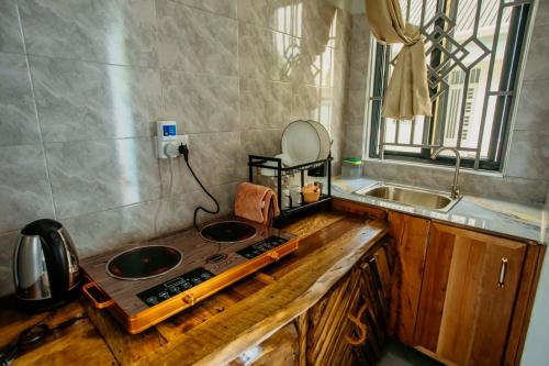 a kitchen with a counter with two sinks and a mirror at Tctc & Camp in Shikurufumi