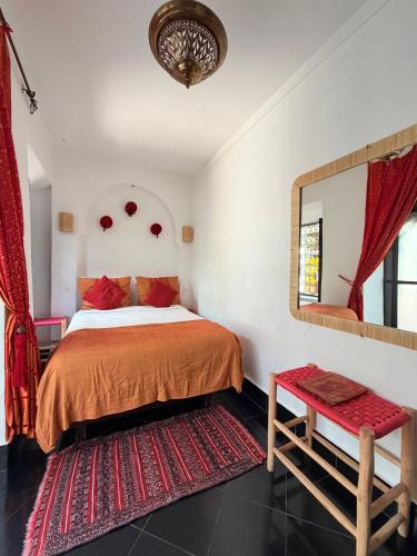 a bedroom with a bed and a mirror and a red rug at Riad Dar Balthazar in Marrakesh