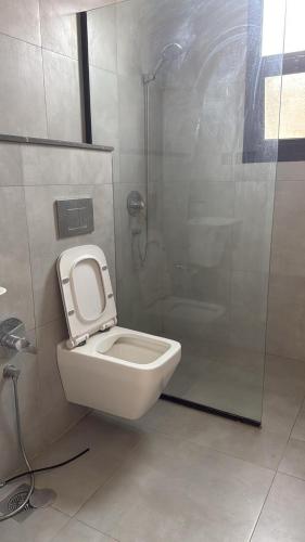 a bathroom with a toilet and a shower stall at شقة تراحيب الشمال للضيافة in Riyadh