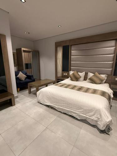 a bedroom with a large bed and a couch at شقة تراحيب الشمال للضيافة in Riyadh