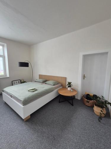 a bedroom with a large bed and a table at LP 1926 aneb U nás doma in Zlín