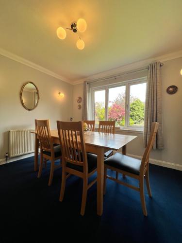 a dining room with a table and chairs and a window at The Rowans B&B in Connel