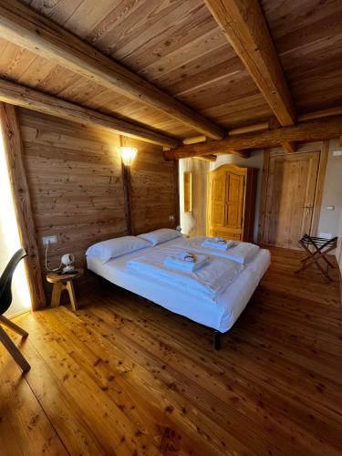 a bedroom with a large bed in a wooden room at L'Antico Piol de Feltre in Feltre