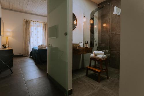 a bathroom with a shower and a bedroom with a bed at Pjazza Suites Boutique Hotel by CX Collection in Siġġiewi
