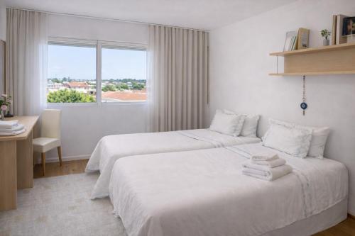 a hotel room with two beds and a window at Free Wave Rooms in Maia