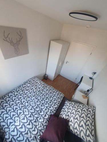 a small bedroom with a bed and a lamp at Angenehmes privatzimmer in Cologne
