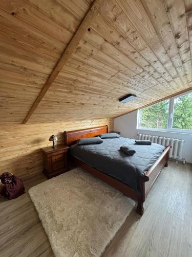 a bedroom with a bed and a wooden ceiling at KraftColibita in Colibiţa
