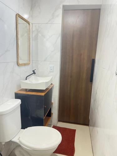a bathroom with a toilet and a sink and a mirror at Apt estiloso 01 in Paragominas