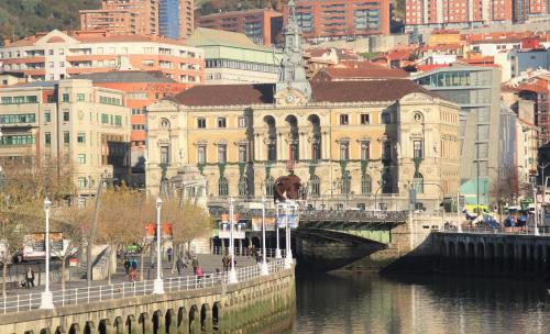 a bridge over a river in a city with buildings at BYPILLOW Irala in Bilbao