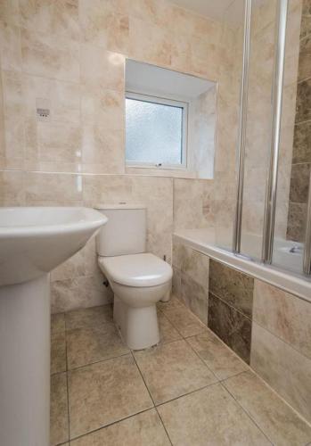 a bathroom with a toilet and a sink and a tub at Riviera Low Tide in Sennen Cove