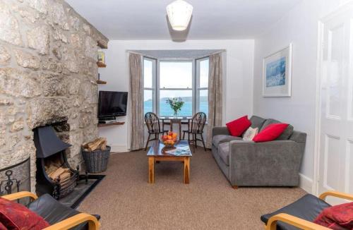 a living room with a couch and a fireplace at Riviera Low Tide in Sennen Cove