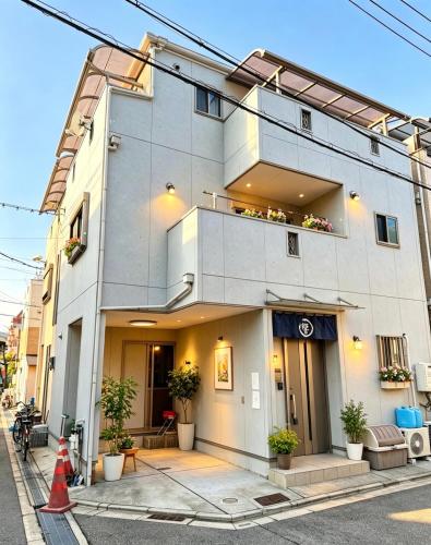 a white building with plants on the side of it at hibiki hotel osaka in Osaka
