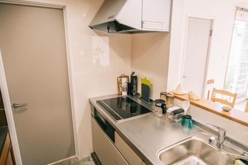 a small kitchen with a sink and a counter at Coucou House Gra in Toyooka