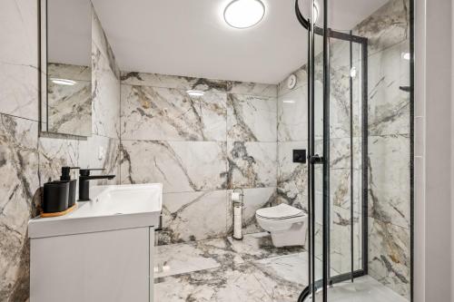 a bathroom with a toilet and a glass shower at Platinum Elite Residence in Rybnik