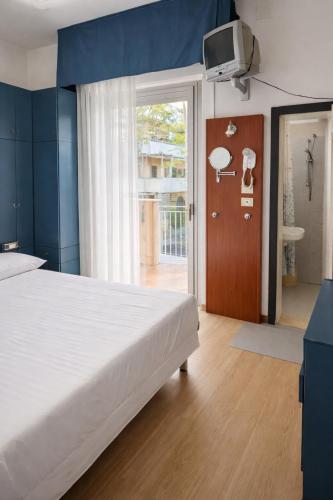 a bedroom with a large bed and a sliding glass door at Dipendenza Hotel Regal in Rimini