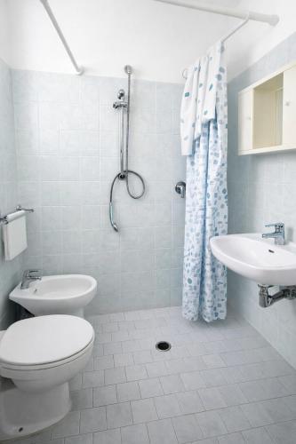 a white bathroom with a toilet and a sink at Dipendenza Hotel Regal in Rimini
