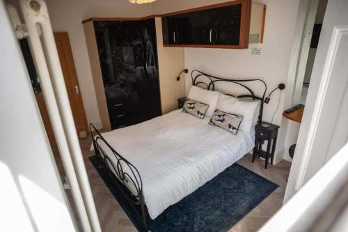 a small bedroom with a bed with white sheets and pillows at Sea View Ultimate Boutique escape! in Barnstaple