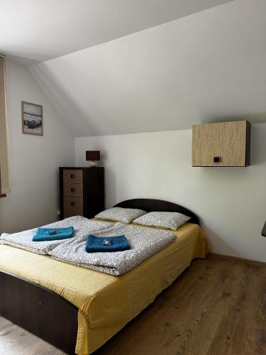 a bedroom with a bed with two blue towels on it at ahoj PRZYLESIE in Pobierowo
