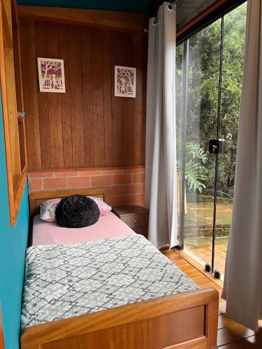 a bedroom with a bed and a large window at Suite Familia A1 in Pomerode