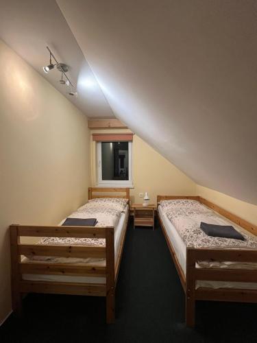 a room with two beds and a window at Domček Ami in Stará Lesná