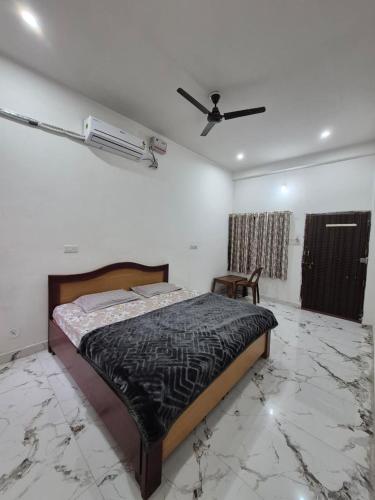 ein Schlafzimmer mit Bett und Deckenventilator in der Unterkunft Hotel Seva Simran in Chhatarpur