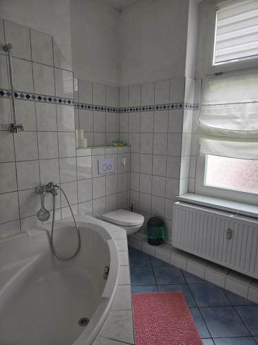 a bathroom with a bath tub and a toilet at Ferienwohnung 1 am Bahnhof in Bernburg