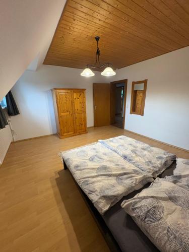 a large bed in a room with a wooden ceiling at Ferienwohnung Stephinsky in Bad Münstereifel