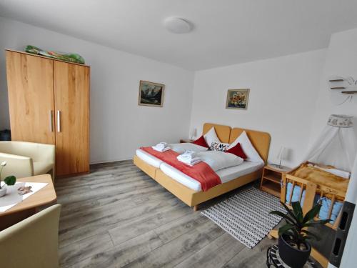a bedroom with a bed and a couch and a table at Piroska Pension in Olbernhau