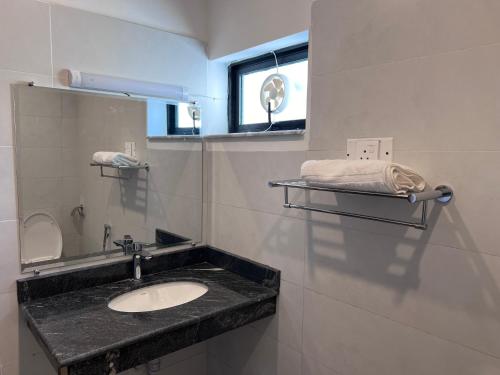 a bathroom with a sink and a mirror at Bridge Residency in Islamabad