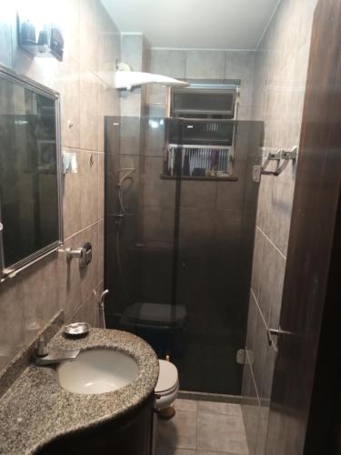 a bathroom with a toilet and a sink and a shower at Quarto no apartamento do anfitrião na Praia do Canto in Vitória