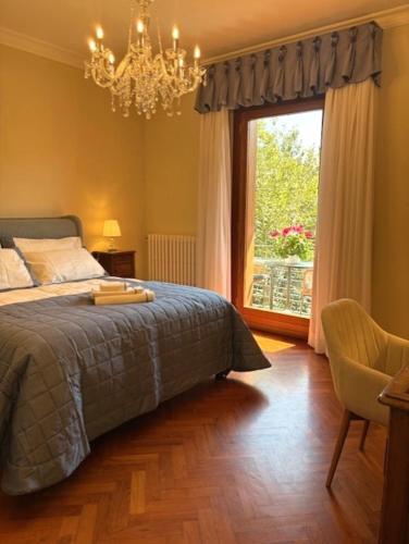 a bedroom with a bed and a window and a chandelier at CuordiSole Tuscany in Montopoli in Val dʼArno