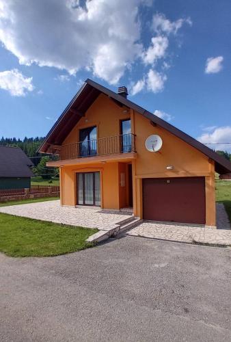 a house with a garage in front of it at Durmitor Sunstone in Žabljak