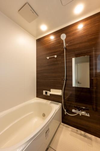 a bathroom with a bath tub and a mirror at 3 Free Rental Bicycles - Free Parking - 85sqm - Up to 9 Guests - 7min to Koreatown - Japanese Lessons by Professional teacher - 自転車3台無料貸出 - 無料駐車場 - 85平米 - 定員9名 - コリアタウン徒歩7分 - Mintak Katsuyama V Residence in Osaka