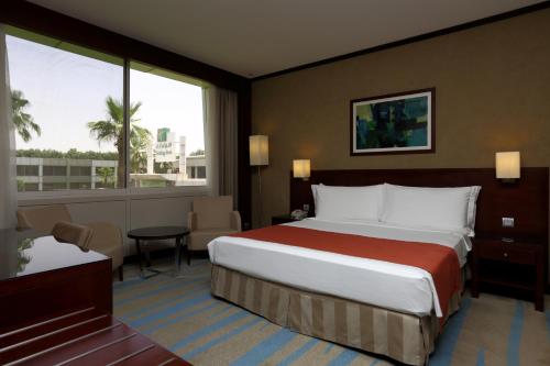 a hotel room with a large bed and a large window at Holiday Inn Riyadh Izdihar by IHG in Riyadh