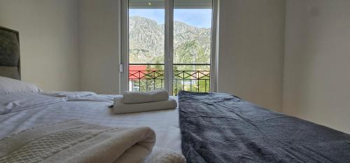 a bedroom with a bed with a large window at Apartments Grgurević in Kotor