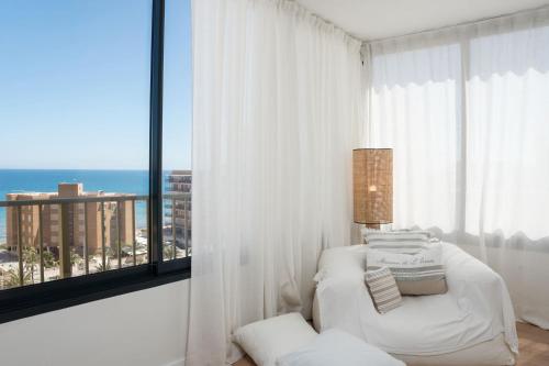 a living room with a white couch and a large window at Luxury Beachfront "Felicità" Sea View 6 Guests in Arenales del Sol